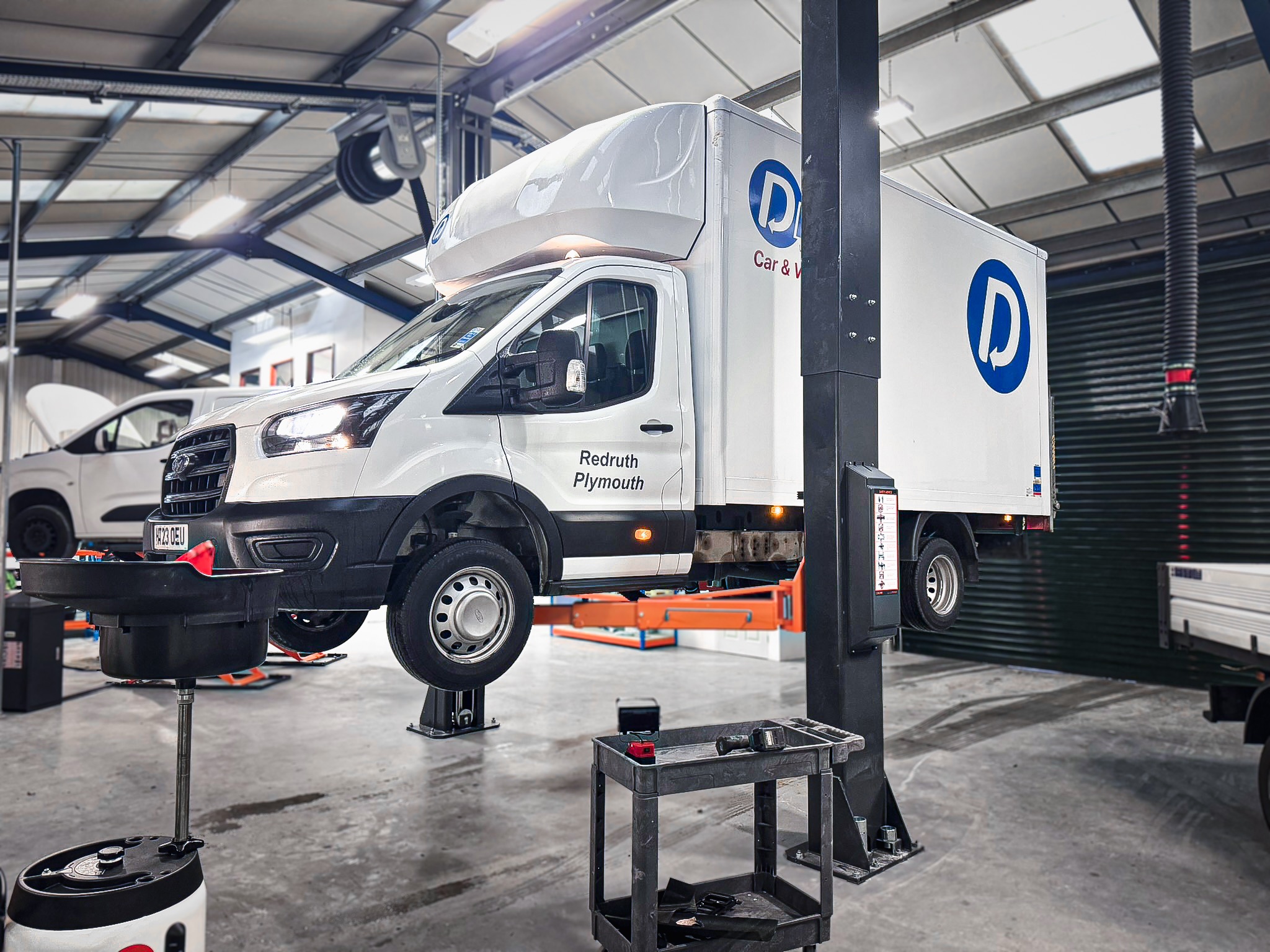 Dash-branded vans on workshop lifts being serviced